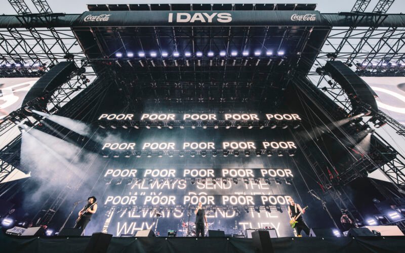 Inquadratura sul palco del concerto dei System of a Down, sugli schermi si ripete una parola. Poor, poor, poor